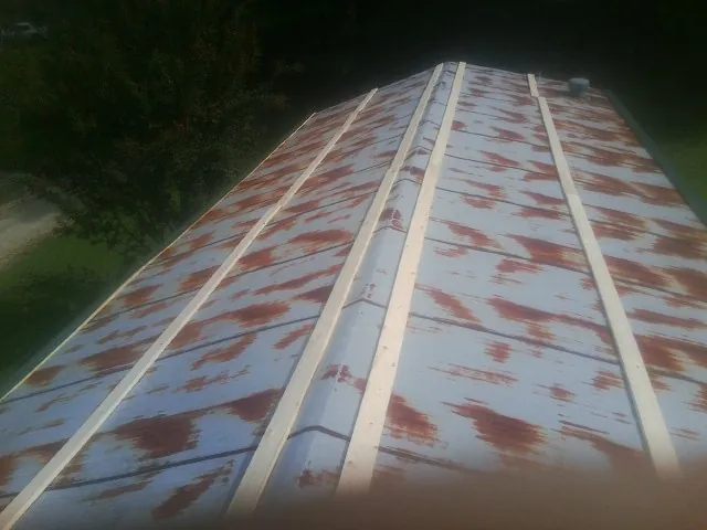 Rusted metal roof panels with new wood purlins before replacement — Storm Damage Roof Repair in Pownal by Roofing Brothers